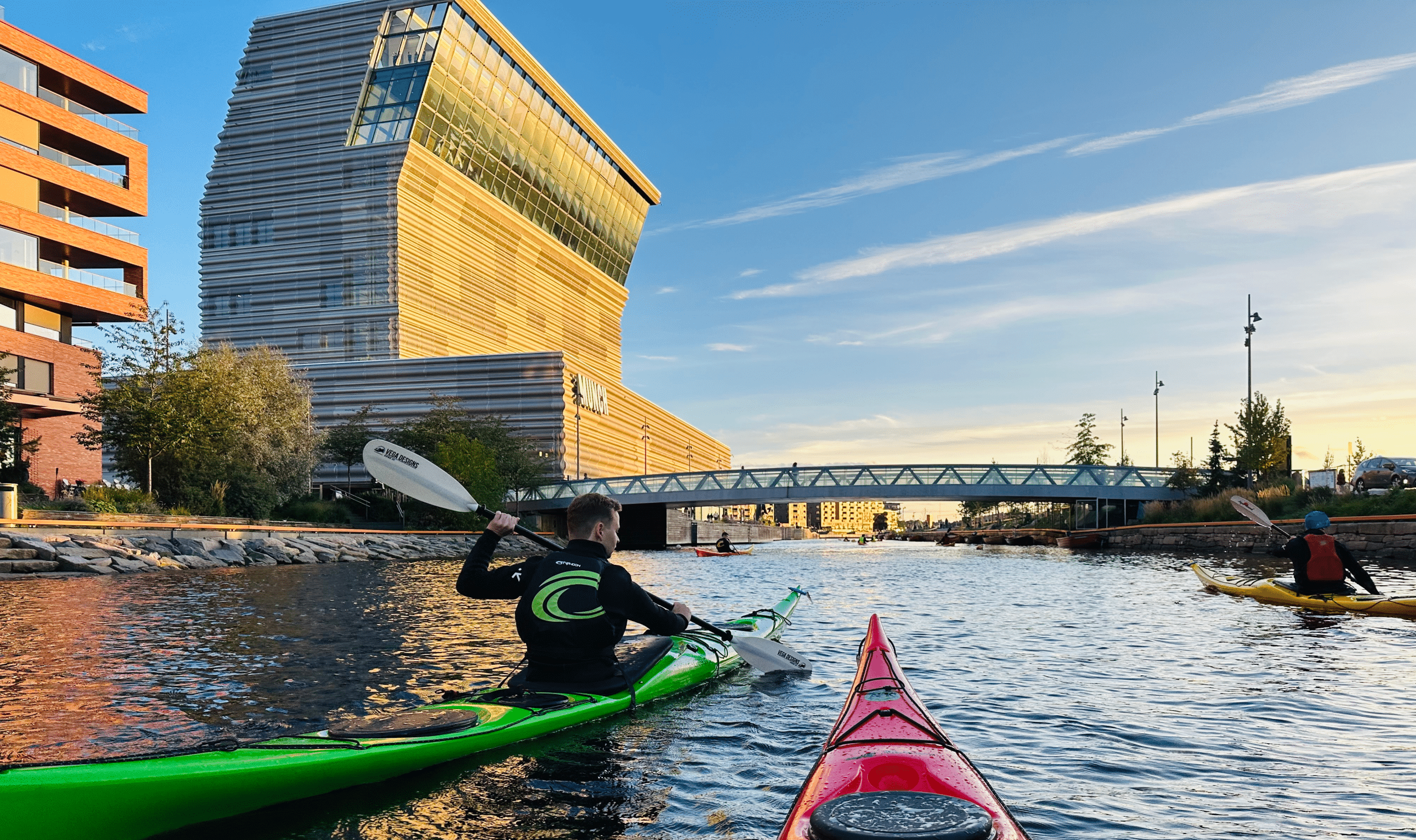 Oslo Kayak Tours. Kayaking past an Oslo sauna with Munch Museum in the background on a Mad Goat kayak tour